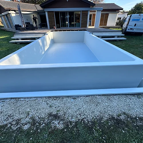 Application d'une étanchéité polyester sur cette piscine débordante sur trois côtés, l'adaptation parfaite de sa forme par le polyester et un atout majeur